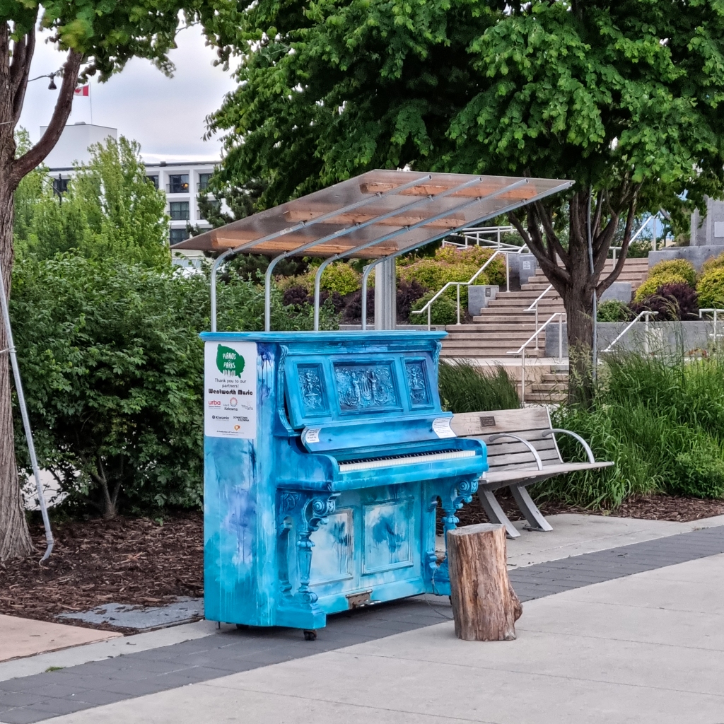 A blue piano, outside on a pedestrian promenade